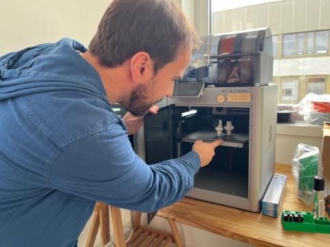 Photo du fabmanager vérifiant une impression en trois dimensions (3D) qu'il a lancée