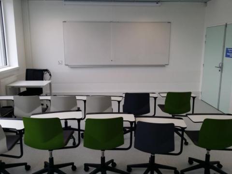 Photo de la salle Cré'Apprendre illustrant la modularité de l'espace : les chaises sur roulettes sont munies de table et placées en deux rangées face à face