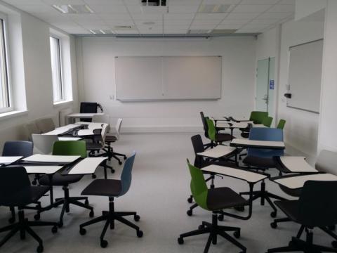 Photo de la salle Cré'Apprendre illustrant la modularité de l'espace : les chaises sur roulettes sont munies de table et rassemblées en petits groupes